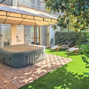 A covered outdoor area with a mattress, a checkered pathway, and a hedge. - Villa Garden - Porto San Giorgio (Porto San Giorgio)