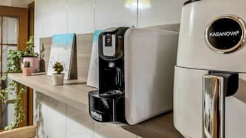 Eine Kaffeemaschine und ein Kühlschrank in einer Küche.