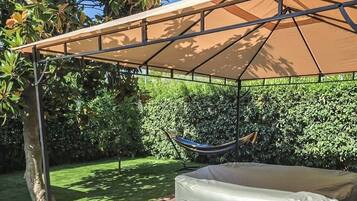 Un espace extérieur abrité, équipé d’un hamac et d’un grand matelas gonflable.