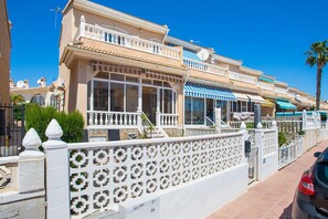 Ein im mediterranen Stil gehaltenes Gebäude mit Balkonen, großen Fenstern und einem verschlossenen Eingang.