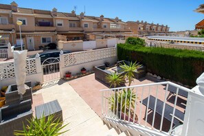 A rooftop patio with outdoor furniture, potted plants, and a white railing. - CH Logroño Doña Pepa (Ciudad Quesada) (Ciudad Quesada)