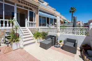 Ein Hotel mit Außenbestuhlung, einer Treppe und Blick auf das Meer.