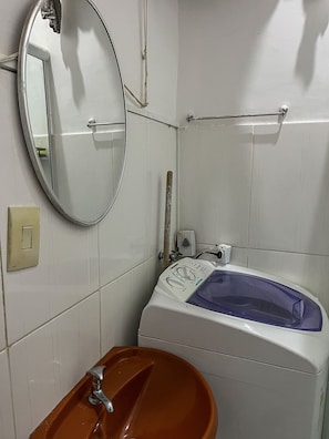 A bathroom with a sink, mirror, and a bathtub. - Studio vista mar pertinho da praia (Rio de Janeiro)