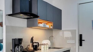 A modern kitchen with a built-in island, dark cabinetry, and a coffee maker.