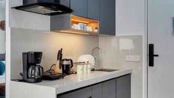A modern kitchen with a built-in island, dark cabinetry, and a coffee maker.