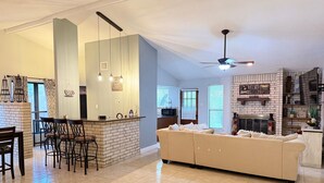 A spacious living area with a kitchen, a dining area, and a fireplace.