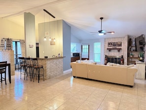 A spacious living area with a kitchen, a dining area, and a fireplace.