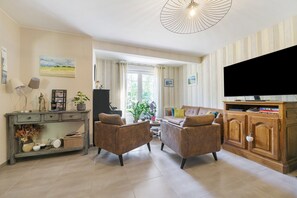 A living room with two sofas, a coffee table, a TV, and a console table with decorative items.