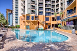 A swimming pool with lounge chairs, a staircase, and a multi-story building with balconies. - Oceanfront Suite w/Balcony-Resort Pools&Lazy River (Myrtle Beach)