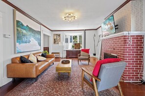 Ein Wohnzimmer mit Kamin, einer Couch, einem Couchtisch und einem Sessel.