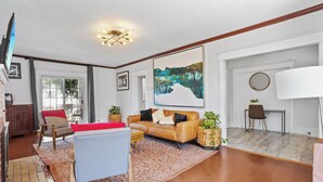 Uma sala de estar moderna com um sofá de couro, uma mesa de centro e uma pintura grande na parede.