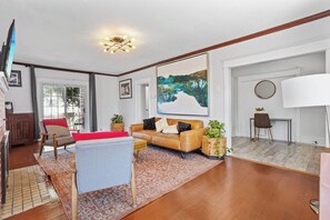 Ein modernes Wohnzimmer mit einem Ledersofa, einem Couchtisch und einem großen Gemälde an der Wand.