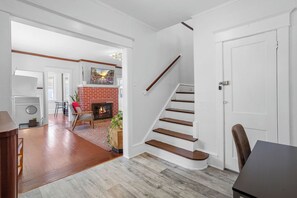 Ein geräumiger Wohnbereich mit Kamin, Treppe und Essbereich.