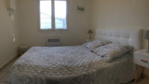 Een slaapkamer met een bed, twee bedlampen, een raam en een radiator.