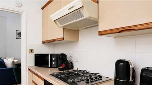 Een keuken met een gasfornuis, een broodrooster en een waterkoker.
