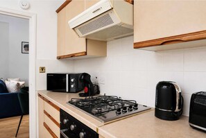 Eine Küche mit einem Gaskochfeld, einem Toaster und einem Wasserkocher.