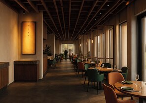 Un restaurante con un largo pasillo, techo de madera y ventanas amplias.