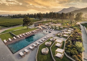 Un complex turístic amb piscina, zones d'oci i jardins paisatges.