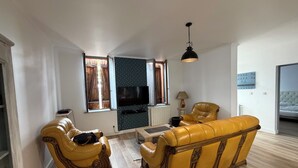 A living room with a sofa, a television, and a lamp. - 4-bedroom family home with a garden and easy parking, just outside Toulouse (Aucamville)