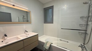 A modern bathroom with a double sink vanity, a glass shower enclosure, and a towel rack. - 4-bedroom family home with a garden and easy parking, just outside Toulouse (Aucamville)