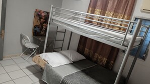 A bunk bed room with a desk, chair, and a painting on the wall. - GROUND-FLOOR HOUSE—GARDEN—ROOMS FOR RENT AND A TERRACE WITH A PING-PONG TABLE (Rivière-Salée)