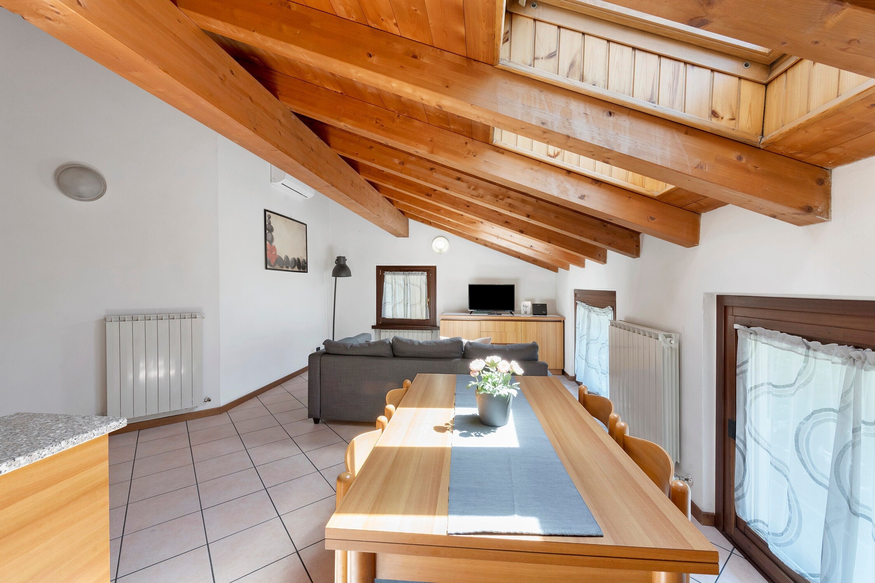 Ein modernes Wohnzimmer mit einem Holzesstisch, einer Couch und einem Fernseher.