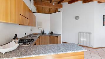 Eine Küche mit Holzausstattung, einer Granit-Arbeitsplatte, einem Gasherd und einem weißen Heizkörper.