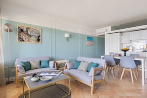 A living room with a sofa set, a coffee table, and a dining area with chairs and a table. - Il Sole di Giada | Sea View by Mondello Bay (Palermo)