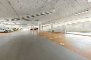 Eine mehrgeschossige Parkgarage mit Betonpfeilern, deutlichen Bodenmarkierungen und einer sauberen, gut beleuchteten Umgebung.