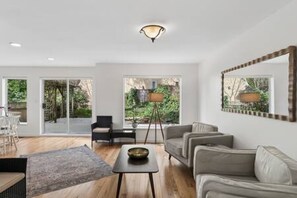 Ein modernes Wohnzimmer mit einer Couch, einem Couchtisch und einer Stehlampe.