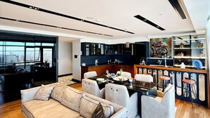 Una sala de estar moderna con sofá, comedor y cocina.