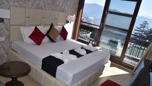 Una cama con vista a las montañas desde un balcón.