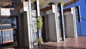 Un edificio moderno con fachada de piedra, ventanas amplias y un balcón con suelo de madera.