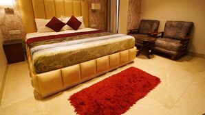 Un dormitorio con una cama grande, dos sillones, una mesita de noche y una alfombra roja.