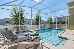 Ein Poolbereich mit Glasverkleidung, Liegestühlen und einem Whirlpool.
