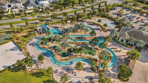 An aerial view of a resort with a large pool area, palm trees, and a golf course. - Themed Villa w/ Pool, Spa, Walk to Water Park (Kissimmee)