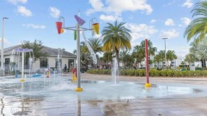 Ein Wasserspiel mit mehreren Brunnen und einer von Palmen gesäumten Fläche.