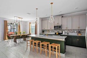 ✨ Open & Inviting! This stunning kitchen and dining area blend modern elegance with warm, earthy tones. Gold accents, sleek cabinetry, and natural wood details create a timeless, cozy vibe. Who's ready to cook & entertain? ️ #DreamKitchen - Themed Villa w/ Pool, Spa, Walk to Water Park (Kissimmee)