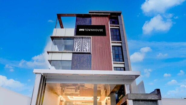 A modern building with a sign reading 'OYO TOWNHOUSE.' - Townhouse Sarnath Temple (Varanasi)