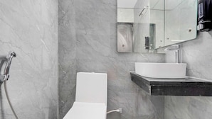 A modern bathroom with a toilet, a sink, and a shower. - Townhouse Sarnath Temple (Varanasi)