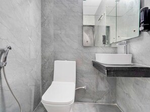 A modern bathroom with a toilet, a sink, and a shower. - Townhouse Sarnath Temple (Varanasi)