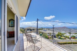 A balcony with a view of a cityscape and a mountain in the distance.