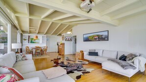 A spacious living area with a white sofa, a wooden dining table with chairs, a white couch, and a large rug. - 4 Mi to Beach! Ocean-view Group Haven in Honolulu (Honolulu)