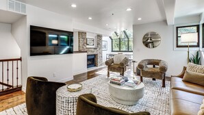 A modern living room with a fireplace, a flat-screen TV, and comfortable seating. - Park City Gem w/ Hot Tub + Sauna: Walk to Main St (Park City)