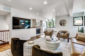 A modern living room with a fireplace, a flat-screen TV, and comfortable seating. - Park City Gem w/ Hot Tub + Sauna: Walk to Main St (Park City)
