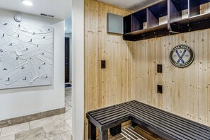 Eine Holzwand mit Sauna-Logo, einer Bank und einem Wandheizkörper.