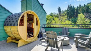 A wooden sauna with a curved roof, a seating area with Adirondack chairs, and a view of a forested area. - Park City Gem w/ Hot Tub + Sauna: Walk to Main St (Park City)