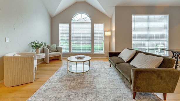 A living room with a high ceiling, a round coffee table, a sofa, and a chair. - 4 Mi to Toyota Stadium! Family Haven w/ Pool Oasis (Frisco)