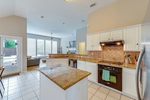 A modern kitchen with white cabinets, granite countertops, and stainless steel appliances. - 4 Mi to Toyota Stadium! Family Haven w/ Pool Oasis (Frisco)