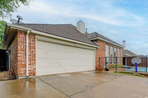 A residential garage with a brick exterior and a white garage door. - 4 Mi to Toyota Stadium! Family Haven w/ Pool Oasis (Frisco)